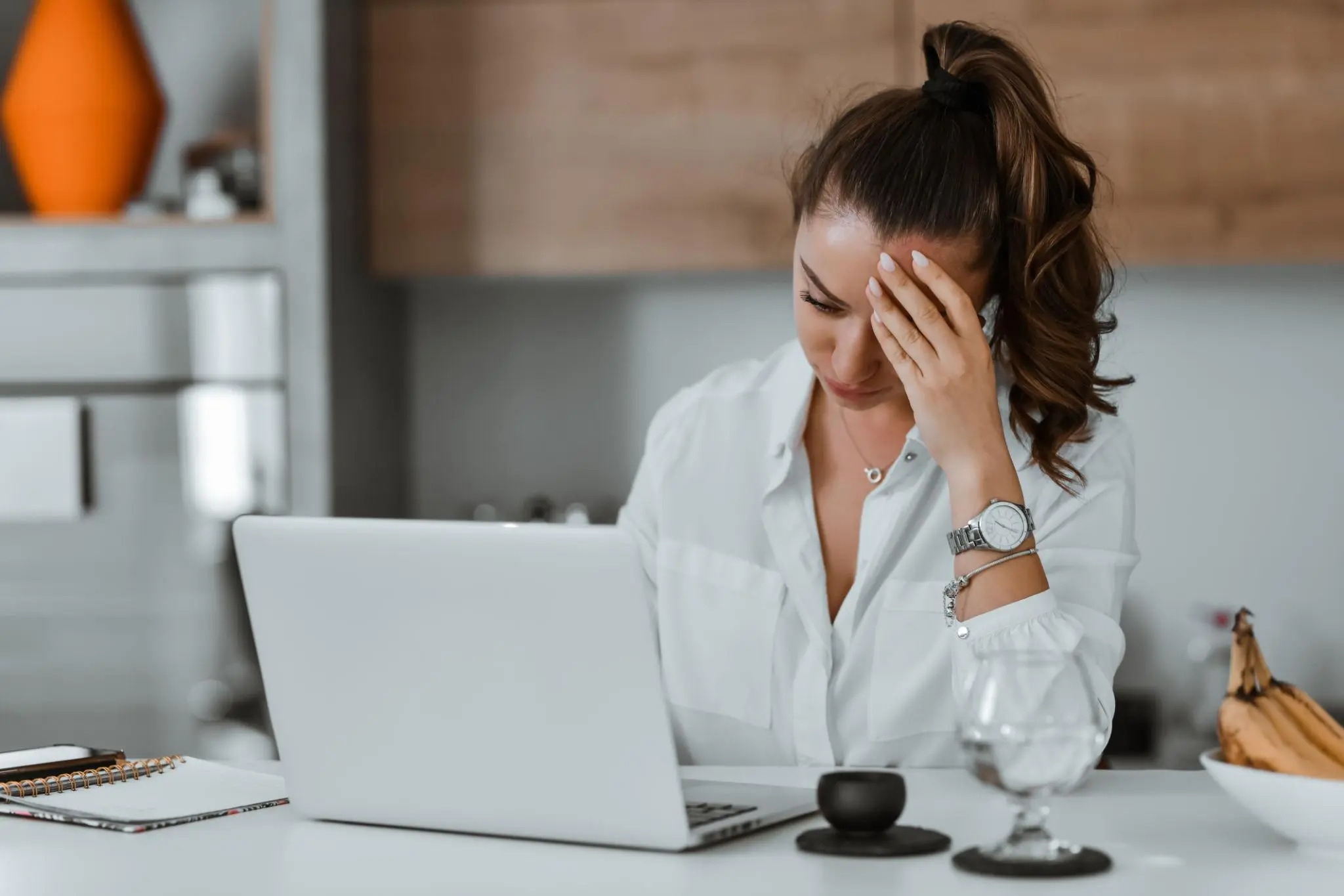 Exhausted professional woman sitting at desk with eyes closed showing signs of burnout